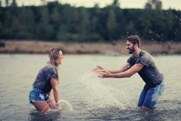 33-feature-man-and-woman-playing-on-body-of-water-trees